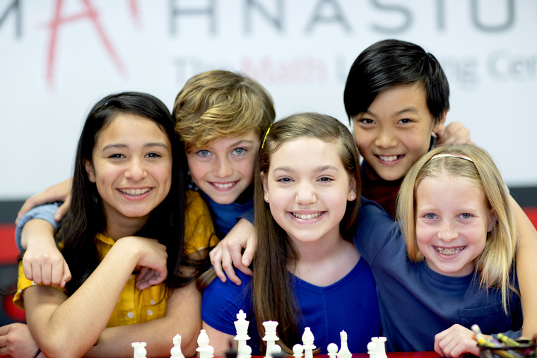 A diverse group of students smiling in a Mathnasium classroom