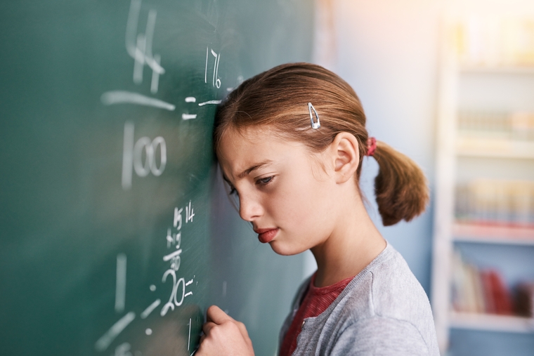 Girl in math classroom, frustrated about a math problem