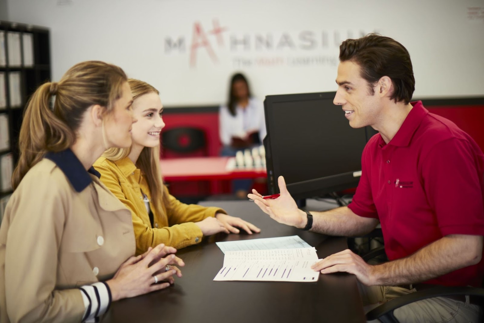 A Mathnasium tutor talking to parent and student