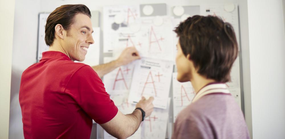 Mathnasium tutor and student next to a whiteboard.