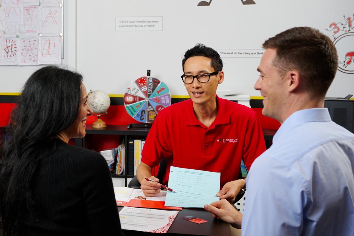 A Mathnasium tutor talks to the parents of a student.