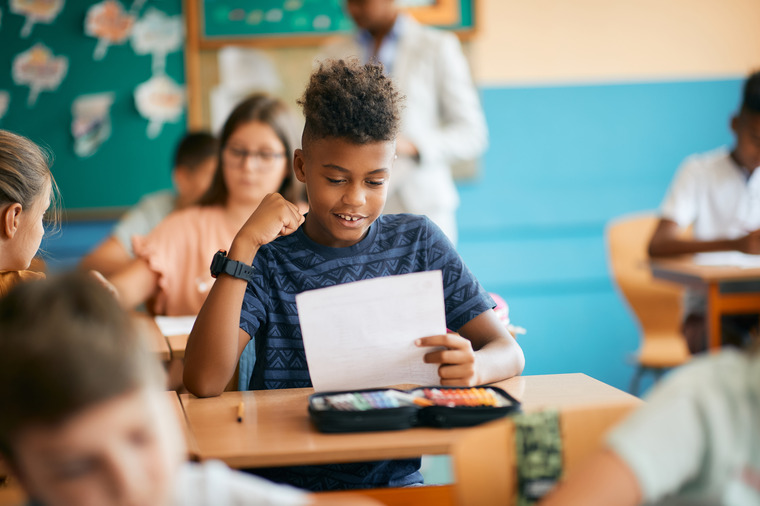 a middle school boy satisfied with his math test results following math tutoring sessions