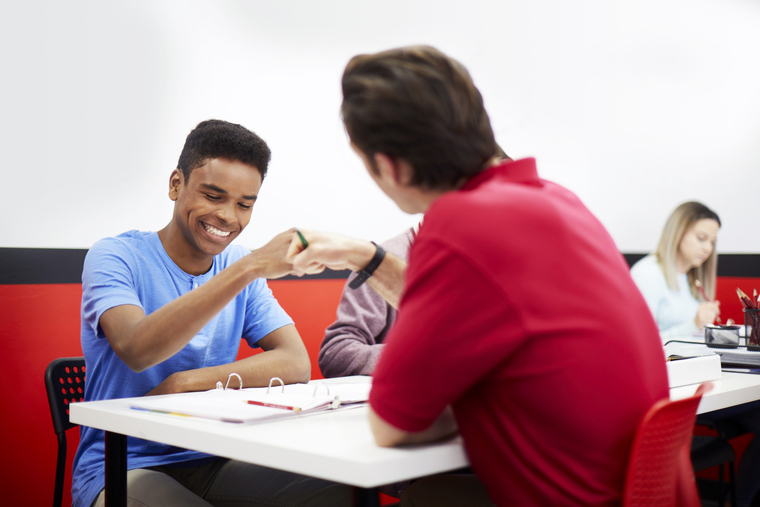 Mathnasium of Lakewood math tutor and student in a classroom fist bumping