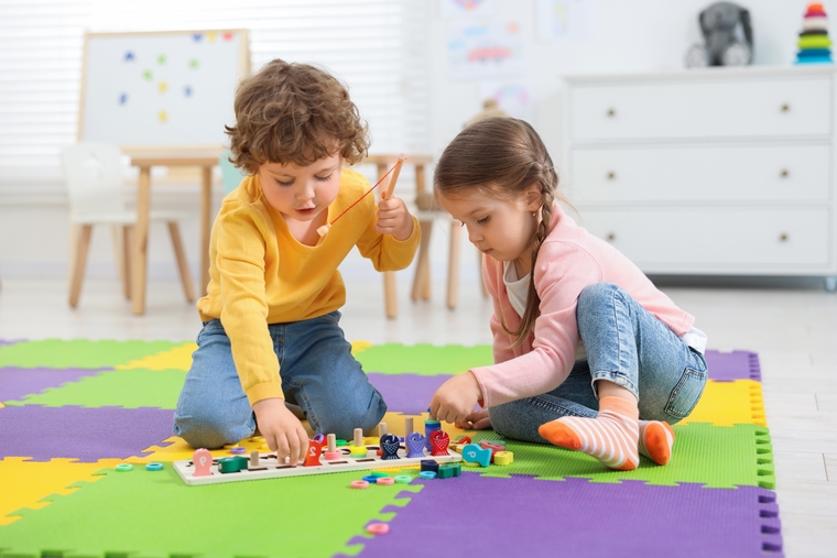 Two young children playing with colorful educational toys to explore counting, patterns, and early math concepts