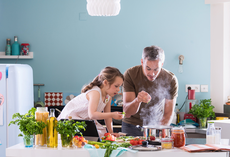 Dad and his daughter cooking a recipe in the kitchen