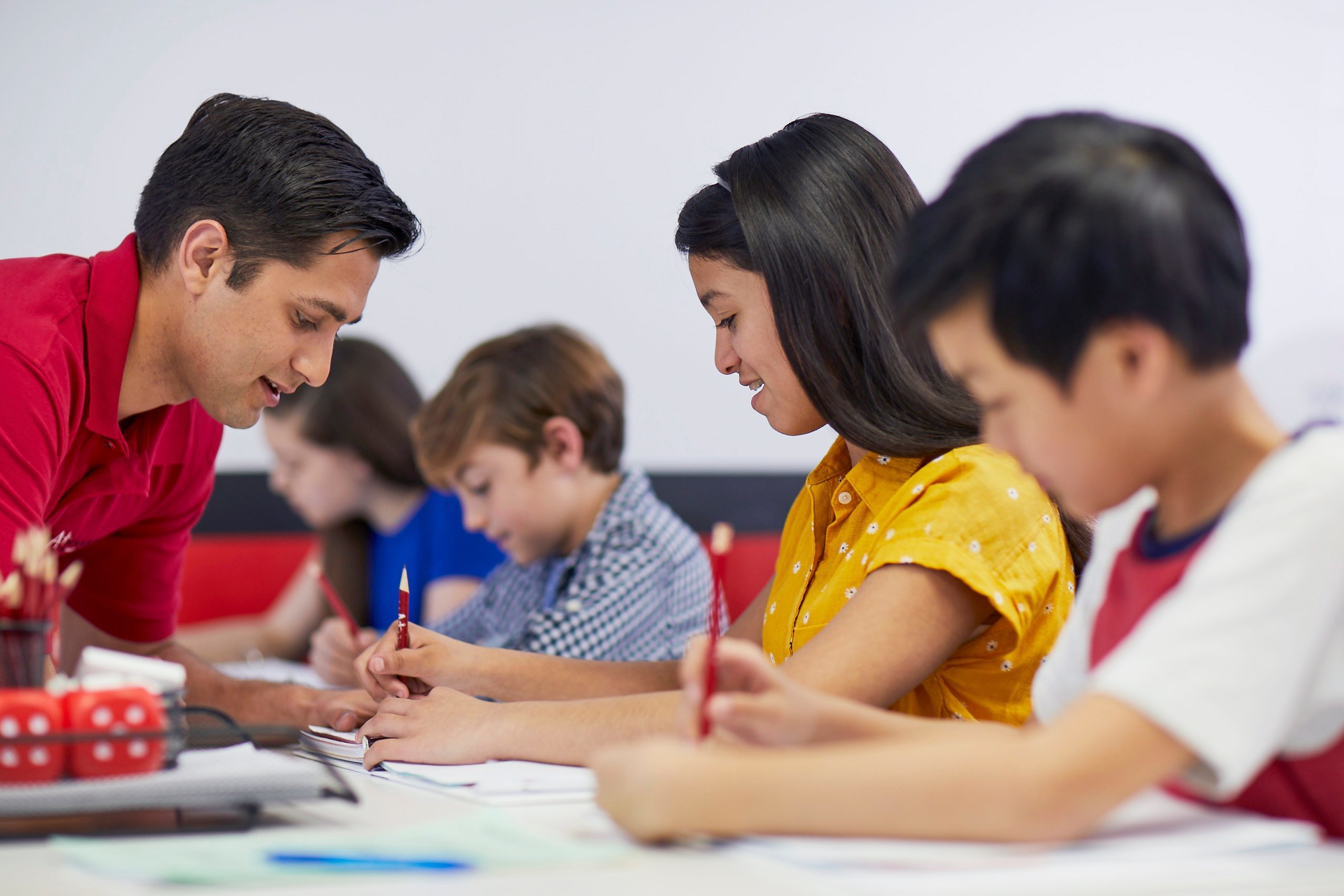 Mathnasium tutor explains math concepts to a student in a learning center.
