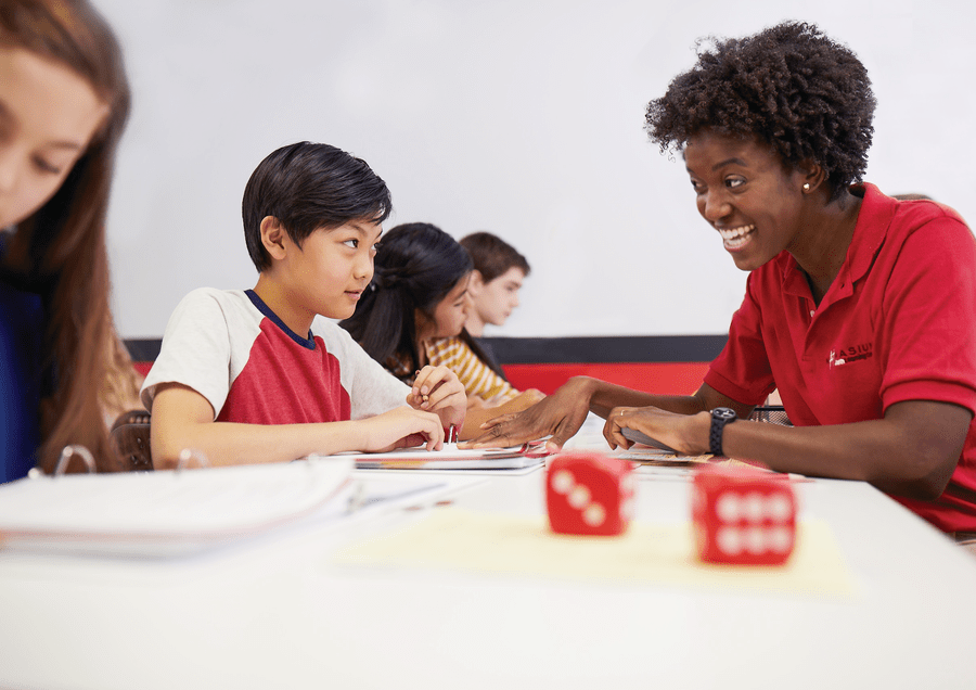 Mathnasium tutor helping a young boy look at a math problem