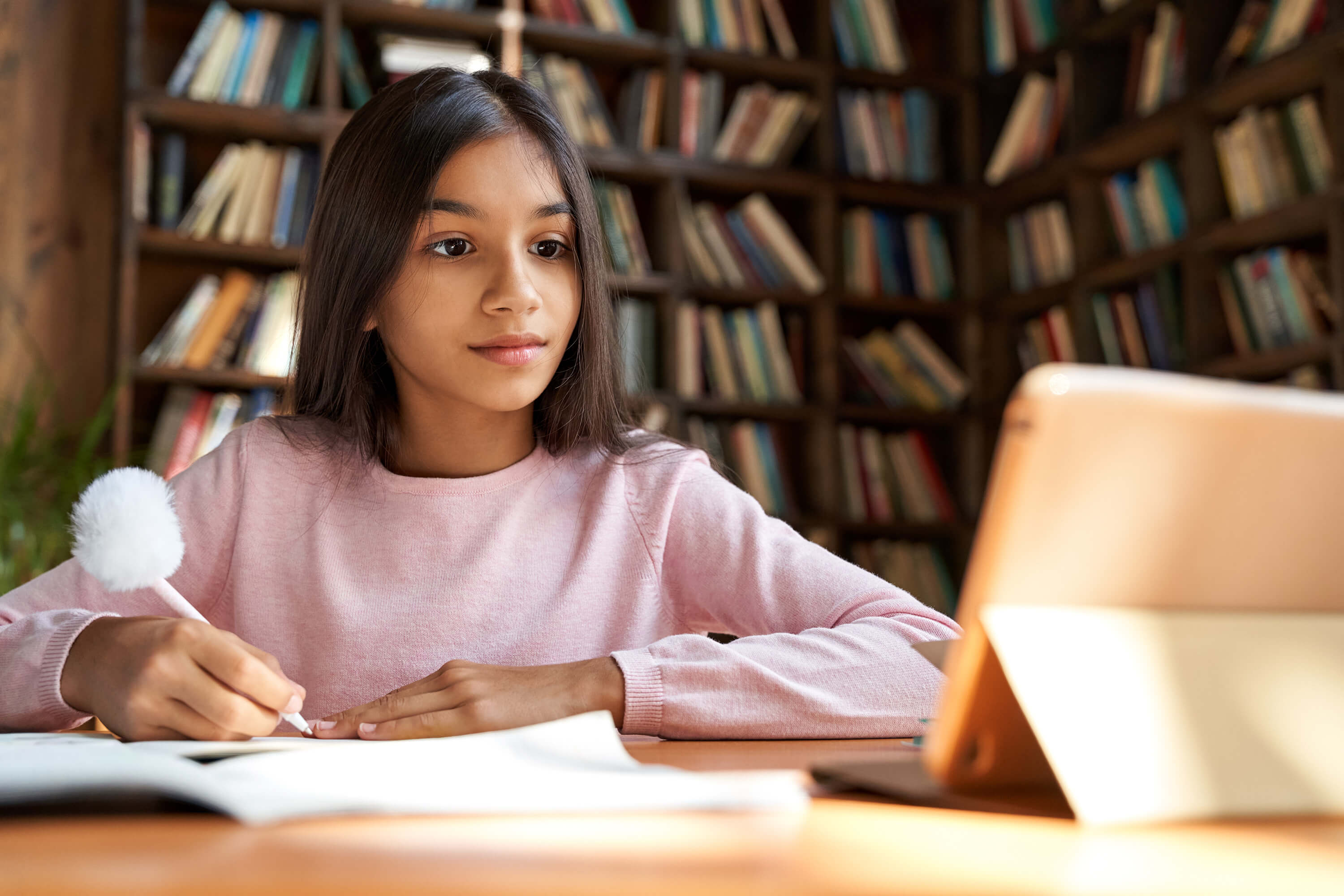 Girl writing on paper at desk