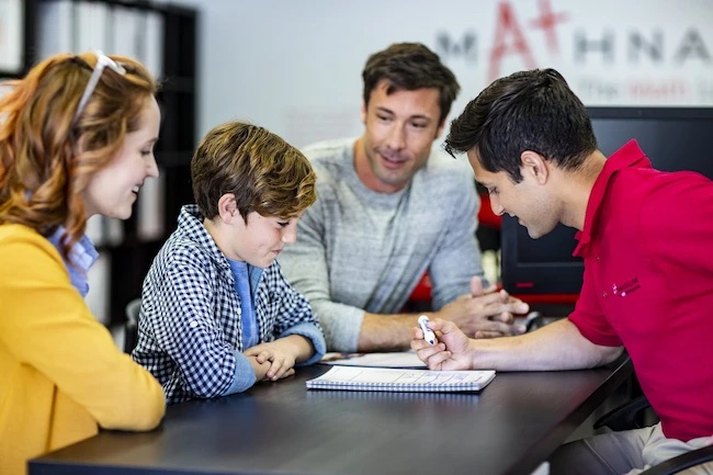 Mathnasium tutor explains a personalized learning plan to student and his parents