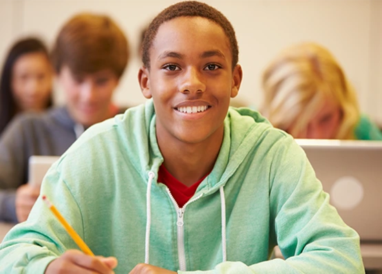 Teenage boy in green hoodie smiling in his geometry tutoring class
