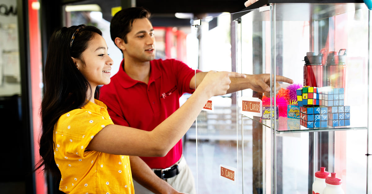 Learning with math tools: student and tutor next to resource shelf