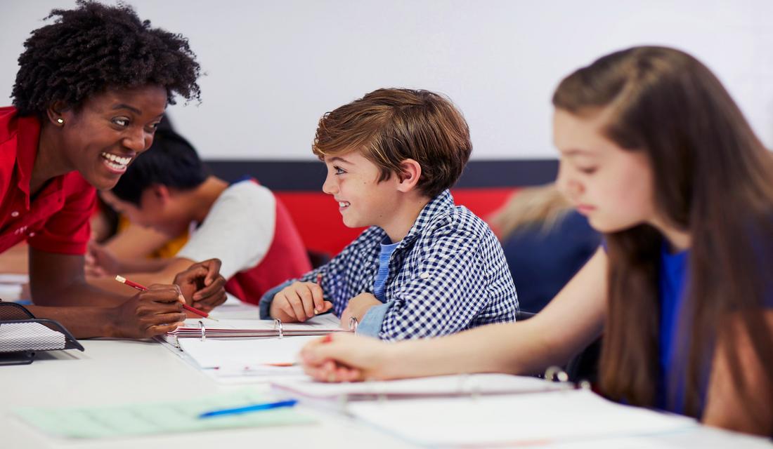 Image of a Mathnasium tutor helping a young student with their work.