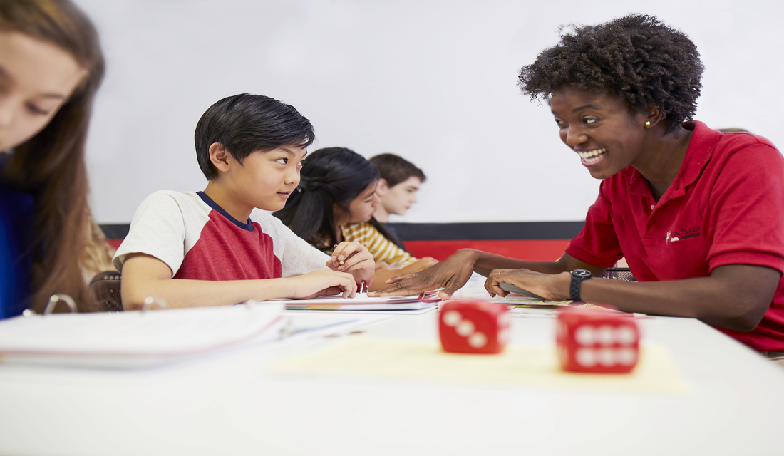 Mathnasium tutor helping a young student with math problems.