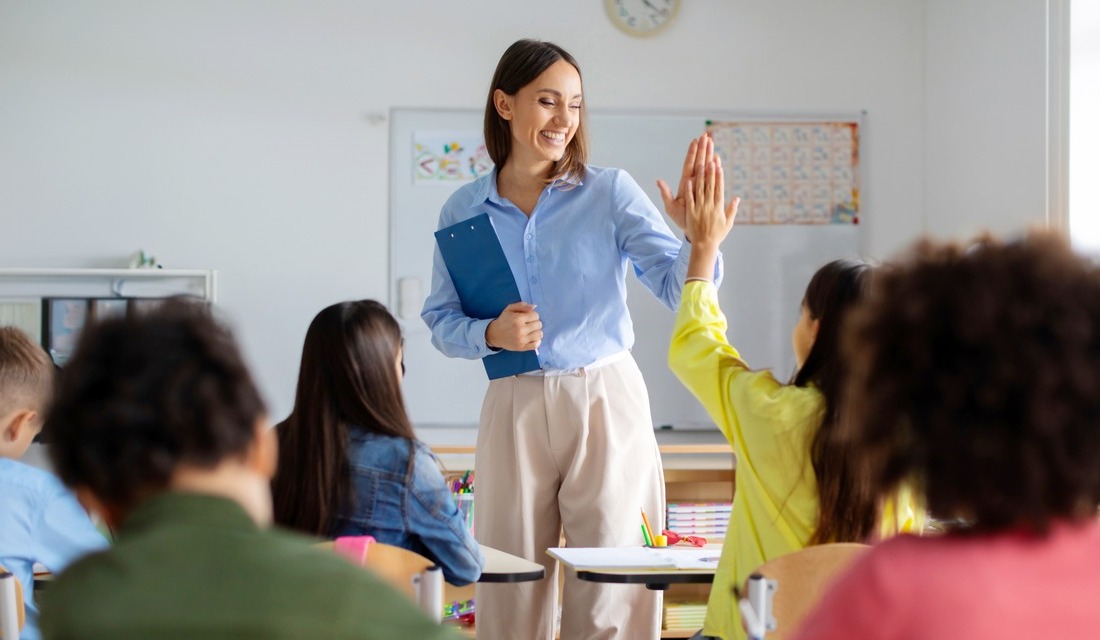 A math tutor high-fiving her student in a small group environment