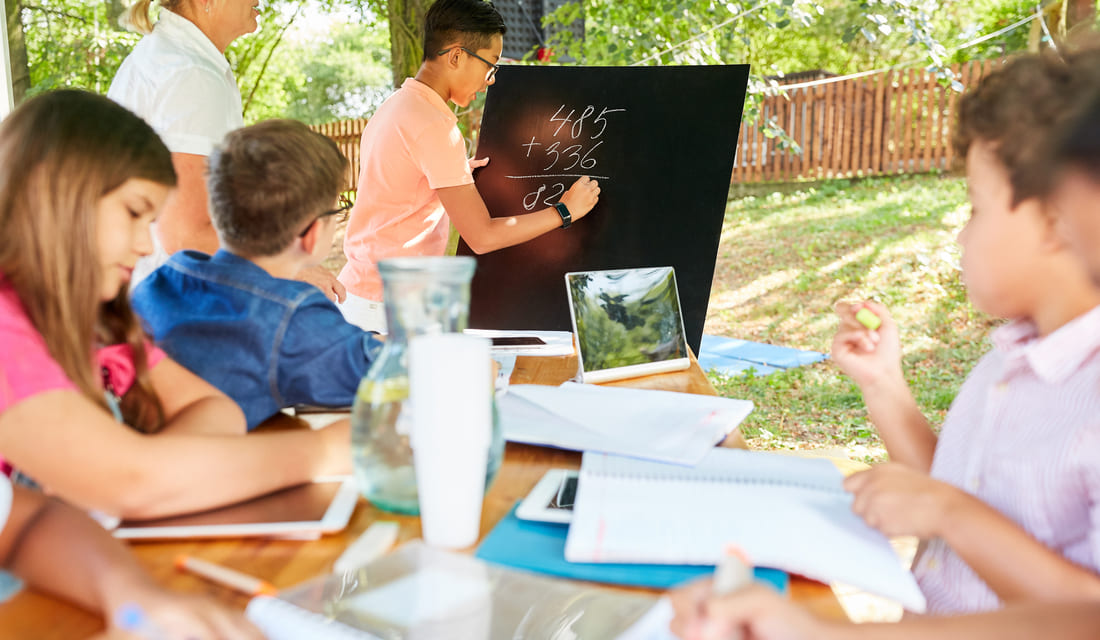 Students receiving math instruction outdoors during a summer learning program.