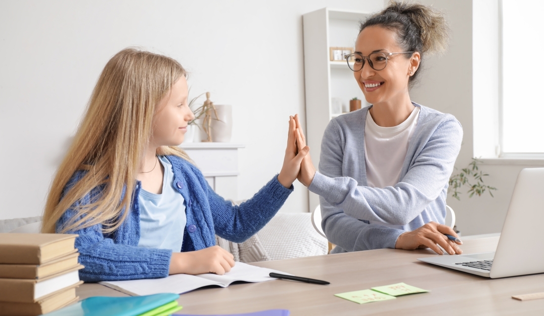 Elementary school student high-fiving her tutor