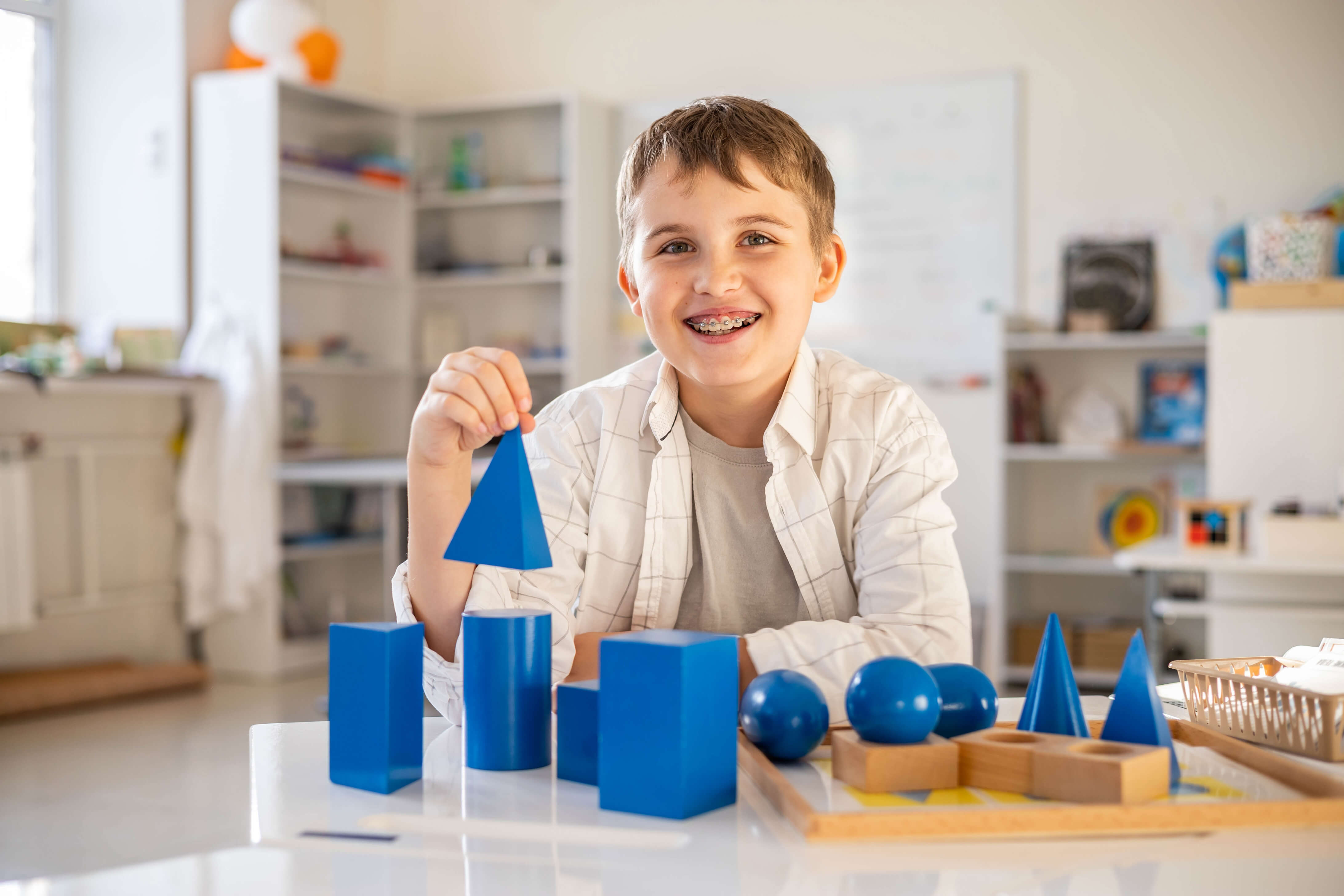 A boy playing with 3D shapes