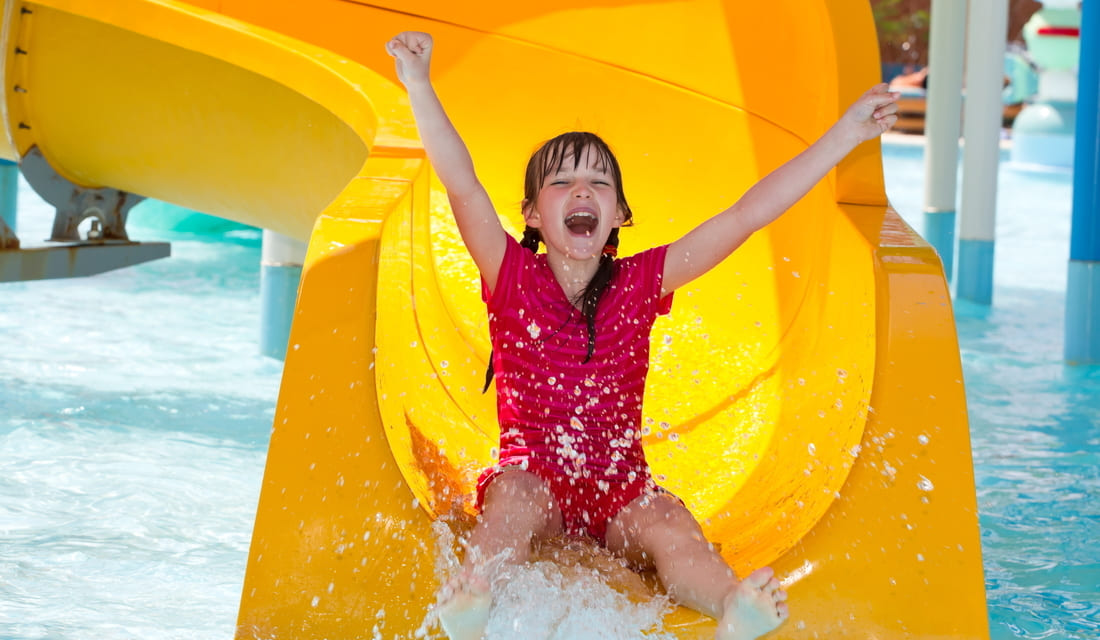 Happy girl sliding down the waterslide