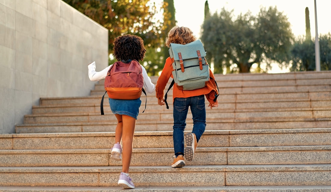 Two school kids climbing a flight of stairs, representing slope in real life