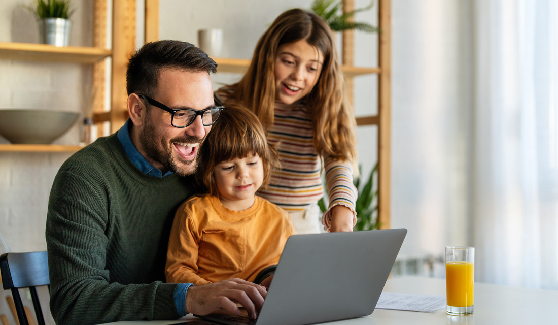 A man and woman with a child are gathered around a laptop, engaged in a shared activity.