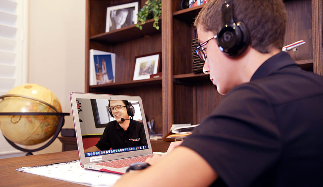 A man wearing headphones, focused on listening, with a neutral background.