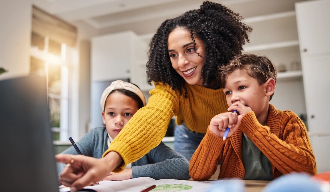 A woman and two children collaborate on a laptop, engaged in a learning or creative activity together.