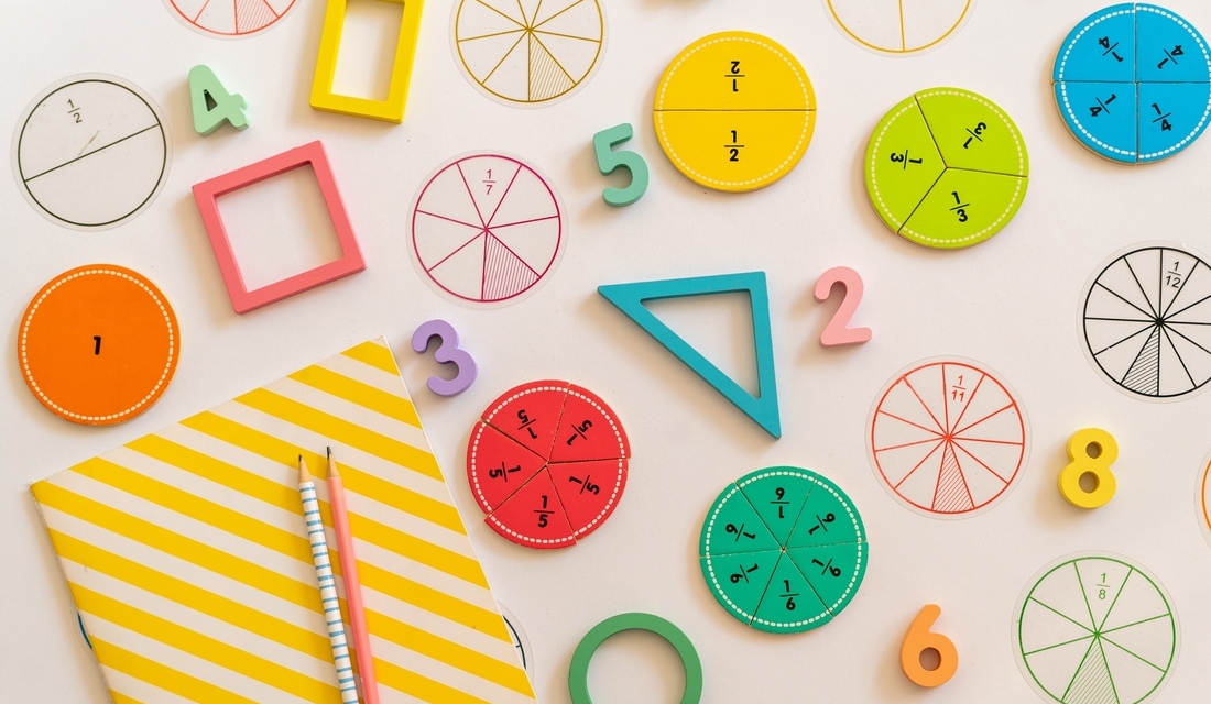 Colorful math shapes and numbers arranged on a white surface, showcasing a vibrant educational display.