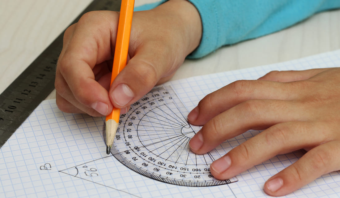 A child focused on drawing on paper with a pencil, showcasing creativity and concentration.