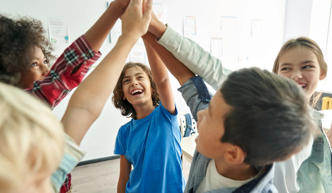A diverse group of children, hands joined together, symbolizing friendship and cooperation in a playful setting.