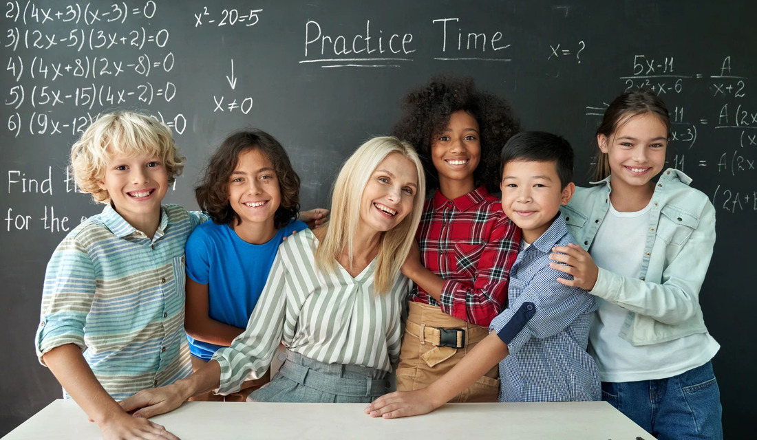 A diverse group of children stands before a blackboard with 