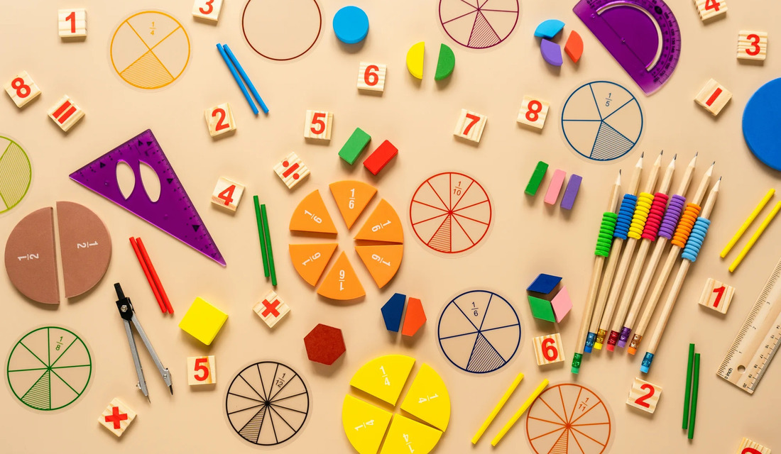 A variety of colored pencils and art tools neatly arranged on a wooden table surface.