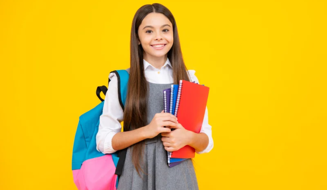 Portrait of a smiling girl holding a school bag and books, set against a bright yellow background.