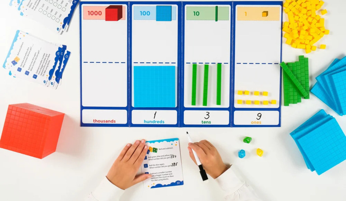 A child focused on a math worksheet, creating a number line with numbers and markers on a desk.