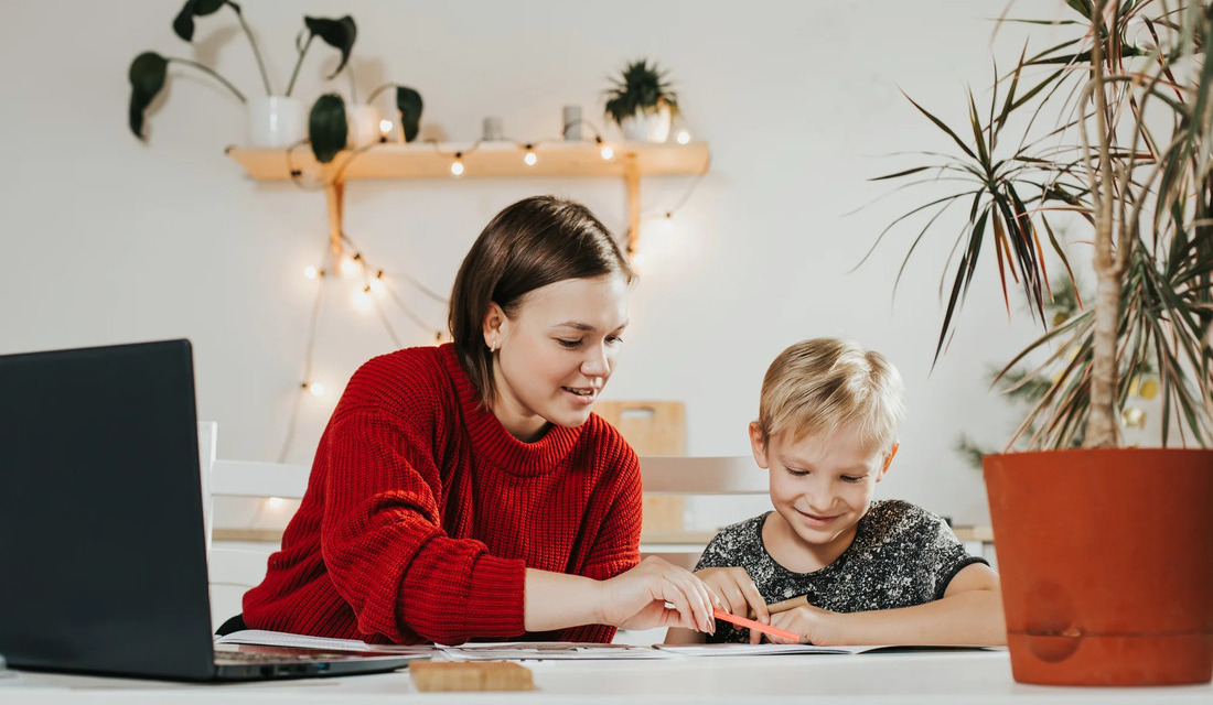 A woman and a child sit together sharing knowledge and skills.